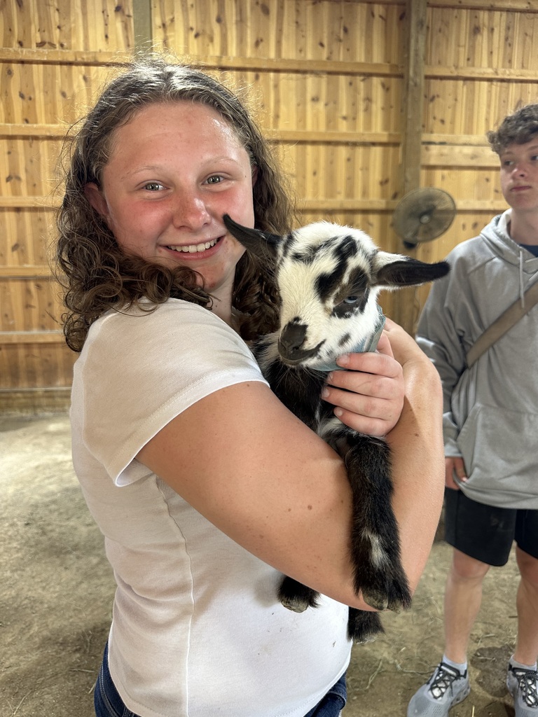 makaila holding a baby goat and smiling