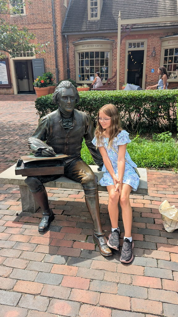 Avery sitting by a statue