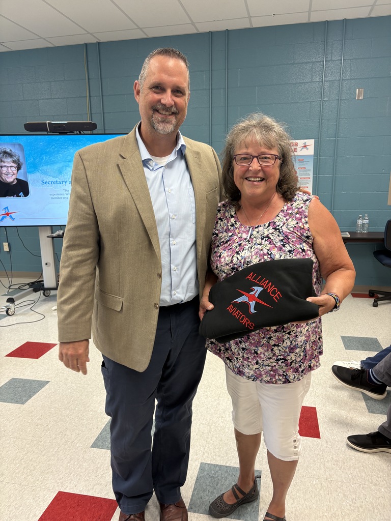 Rob Gress standing with Terri Miller at the Board meeting for a picture