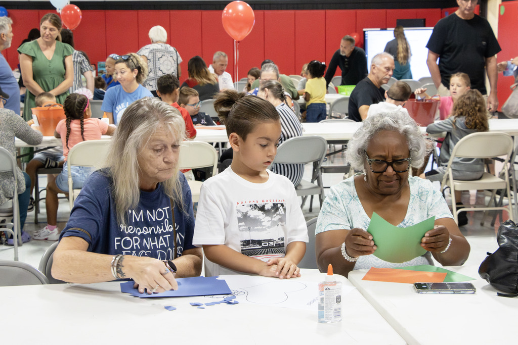 grandparents helping their grandson with a craft