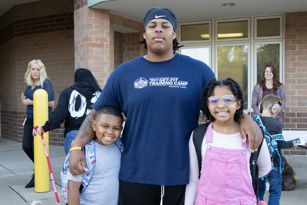 an older brother standing with his younger siblings