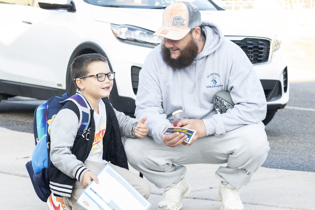A father and son kneeling down and reading