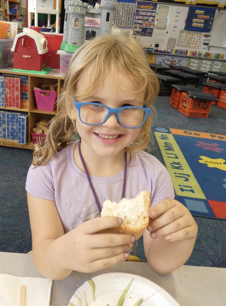 student holding bread she made in class