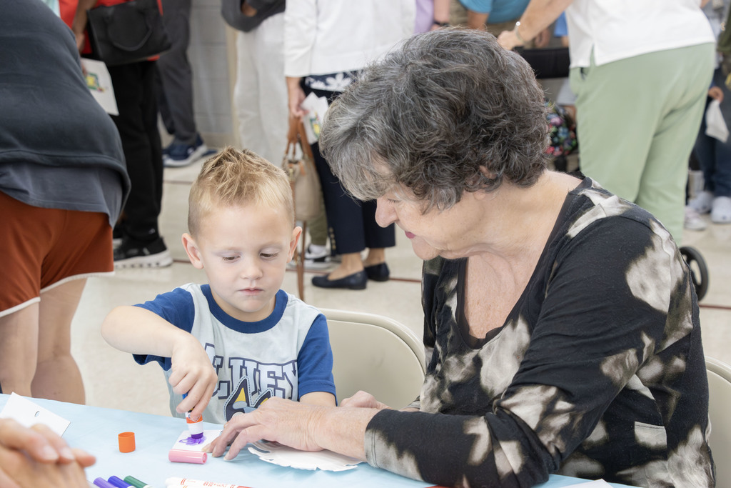 A grandma helping a student with a craft