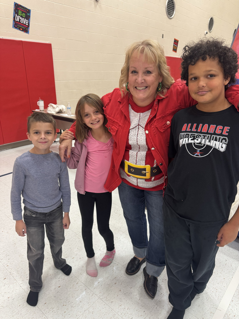 three students smiling with Mrs. Herdman