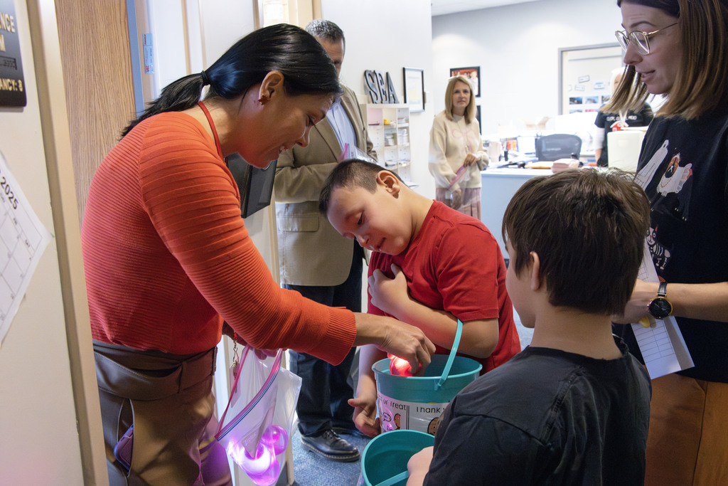 Janet Mackall, the director of special education passes out light up bouncy balls to the trick or treaters