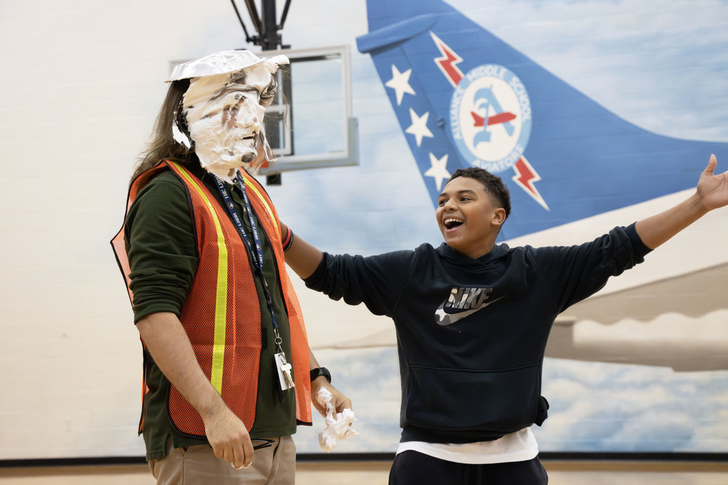 A student cheers after pieing his teacher