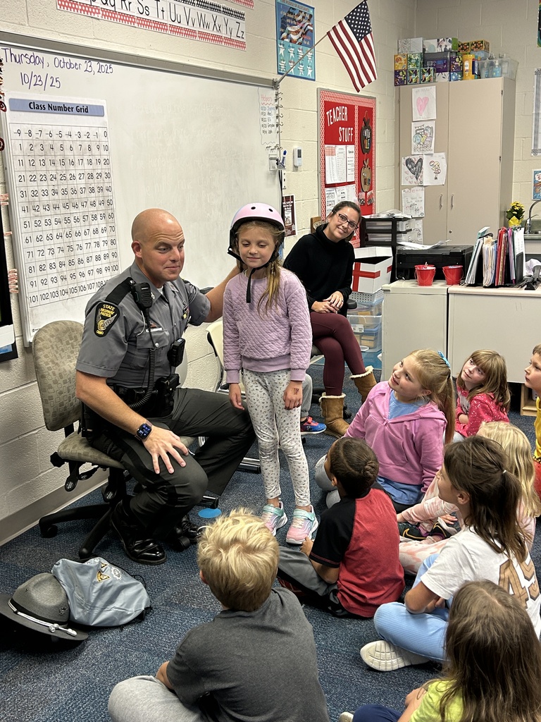 Trooper Shonk helping his daughter with a bike helmet
