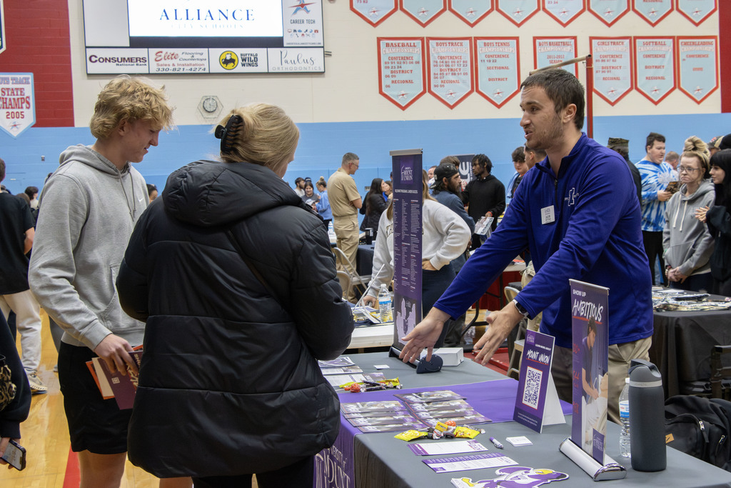 A parent and her son talking a a representative from Mount Union