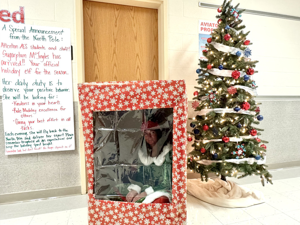 Sugarplum sitting in a box by a christmas tree with the message taped to the wall