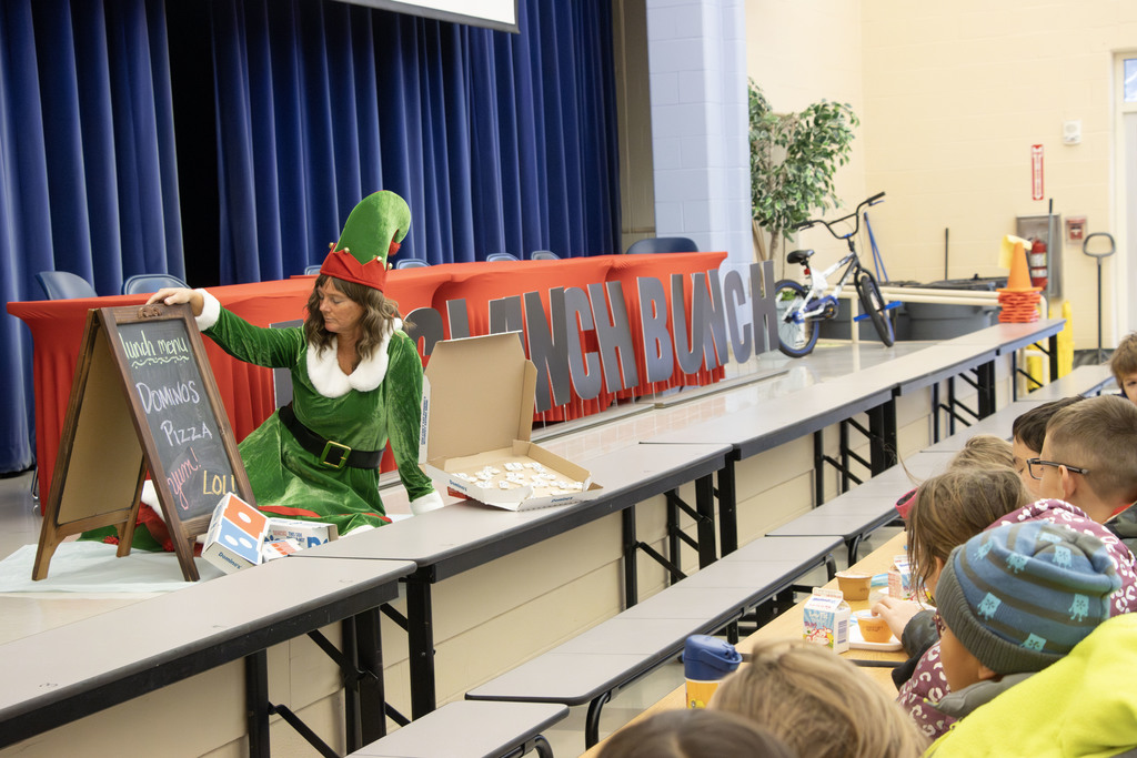sugar plum sitting on the stage while students eat breakfast