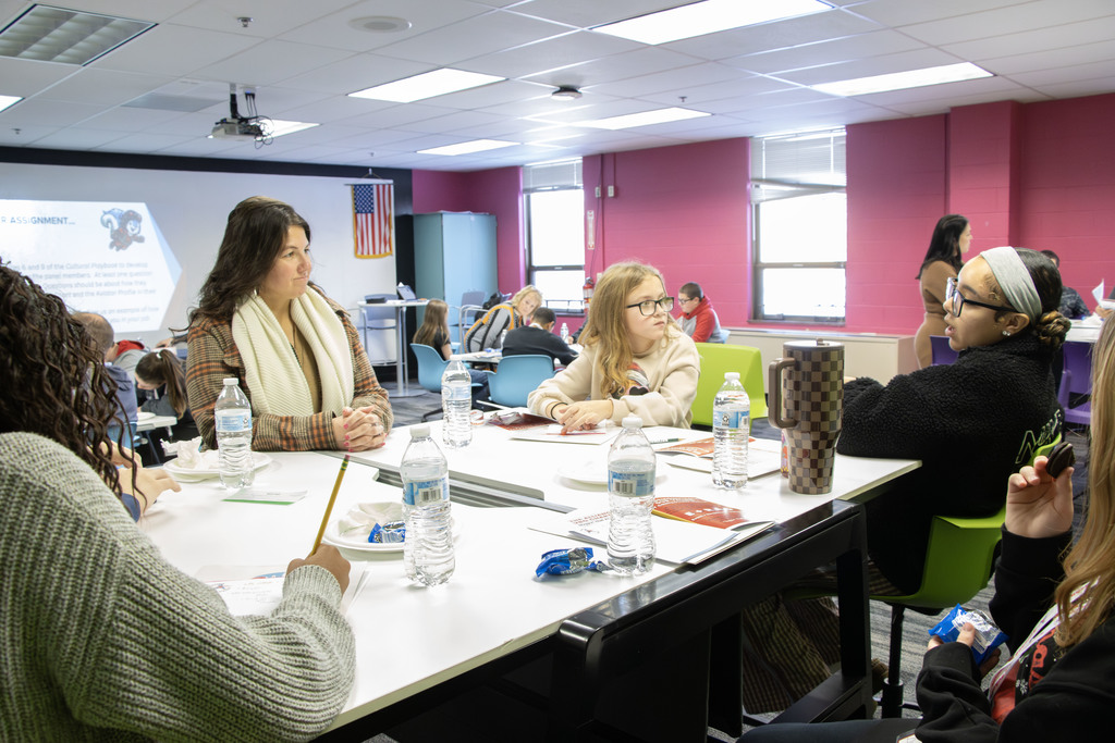 Jayme Smith speaking with a table full of students