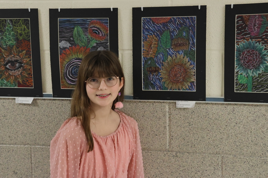 Student standing next to her artwork at last year's Art Show