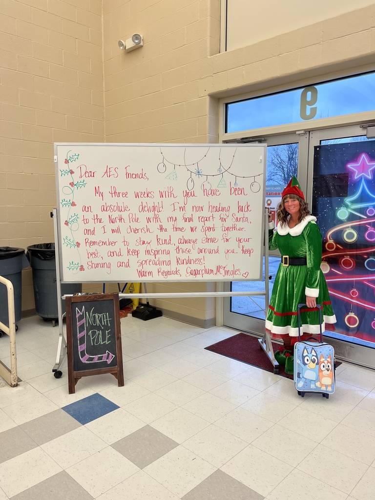 Sugarplum standing next to a message for students with her suit case in hand