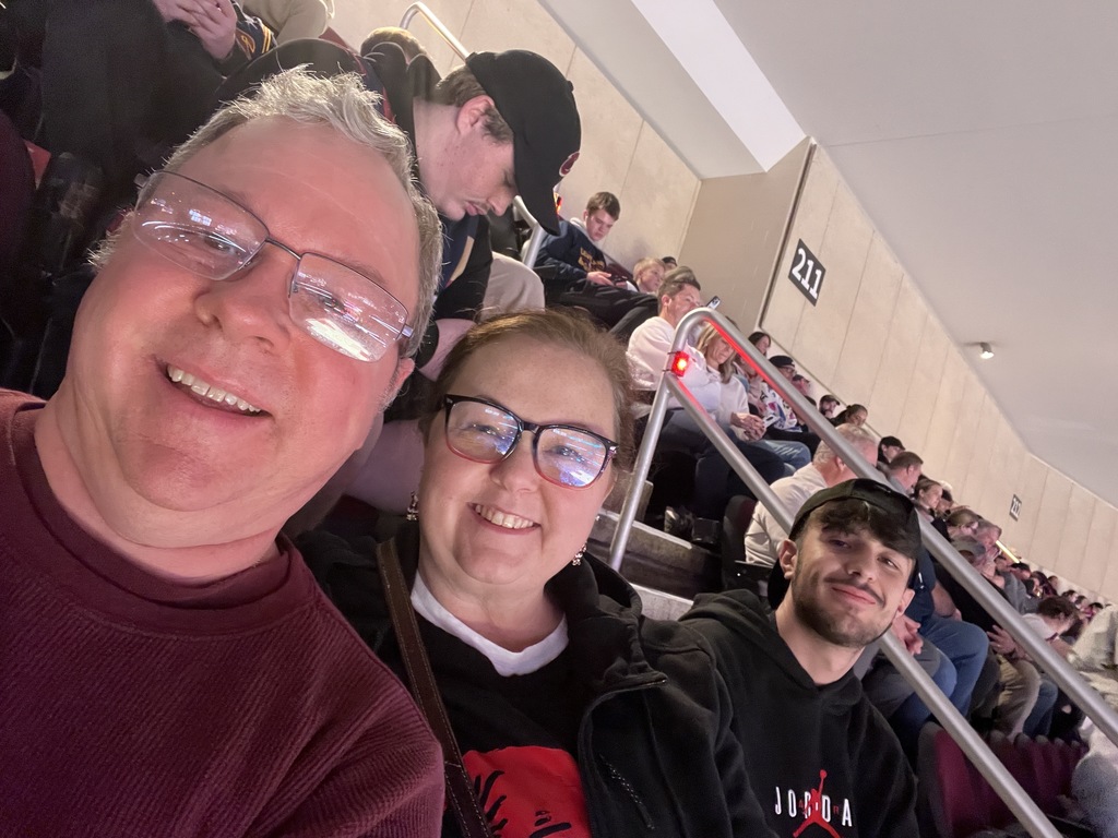 The Dubajs and Marco sitting in their seats at the game