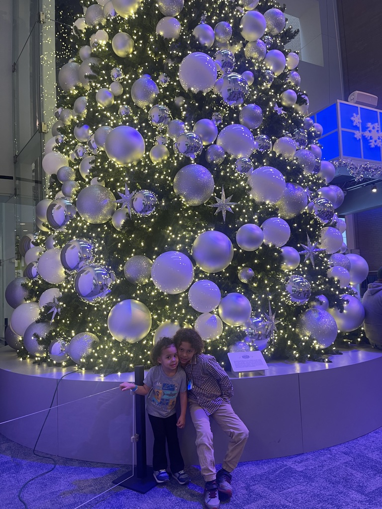 Taiden & Taleah infront of a giant xmas tree at COSI