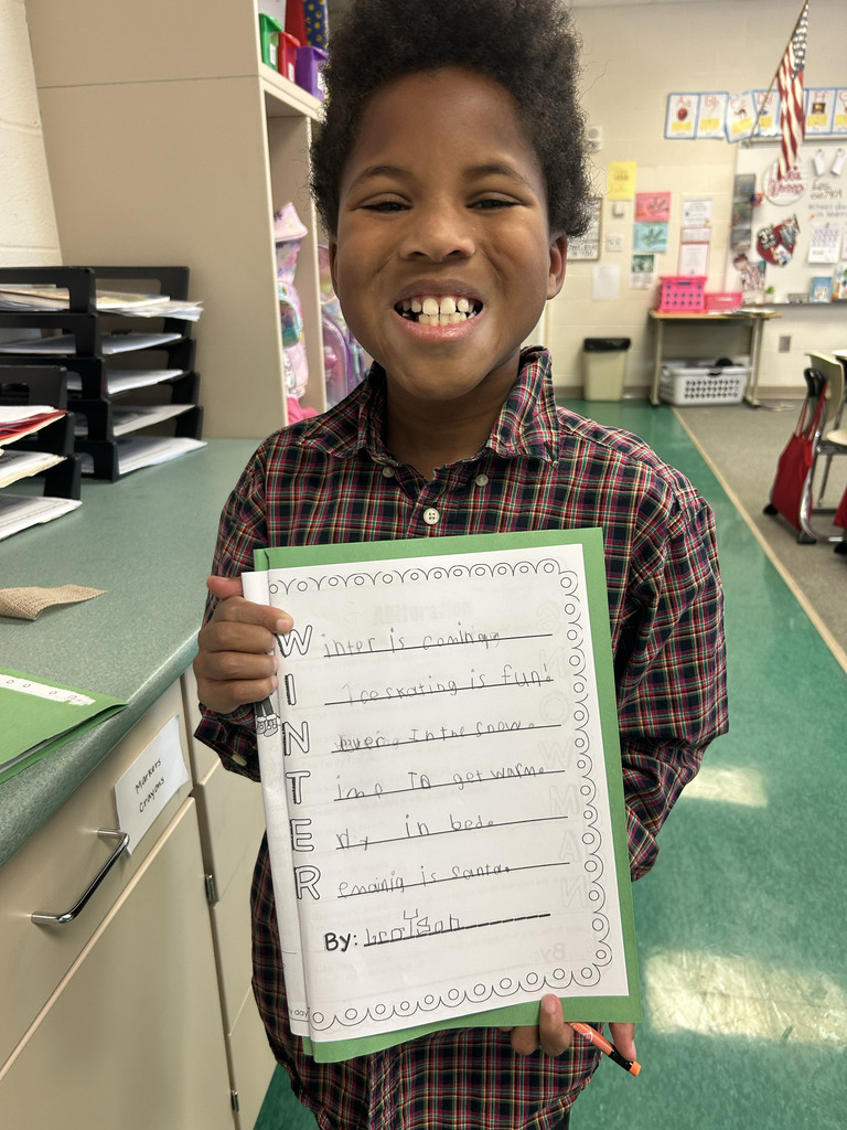 Student holding their poem and smiling