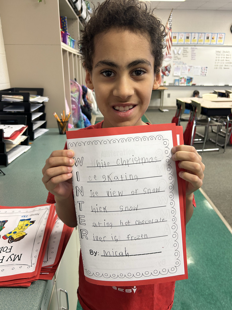 Student holding their poem and smiling
