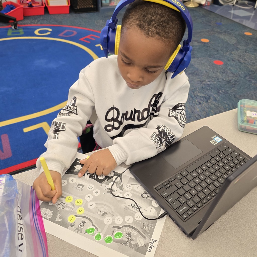 student using a yellow marker to color in his worksheet
