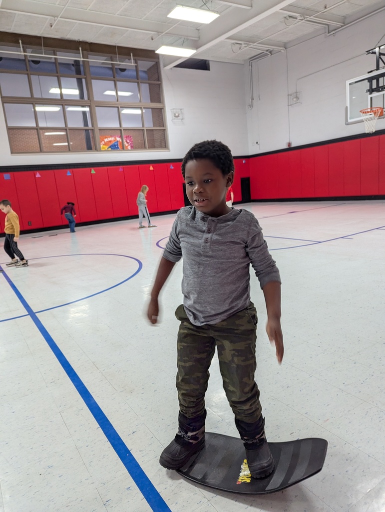 Student standing on a balance board to replicate a snowboard