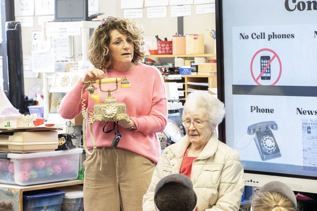 Mrs. Berry holding an old phone like what her grandmother would have used