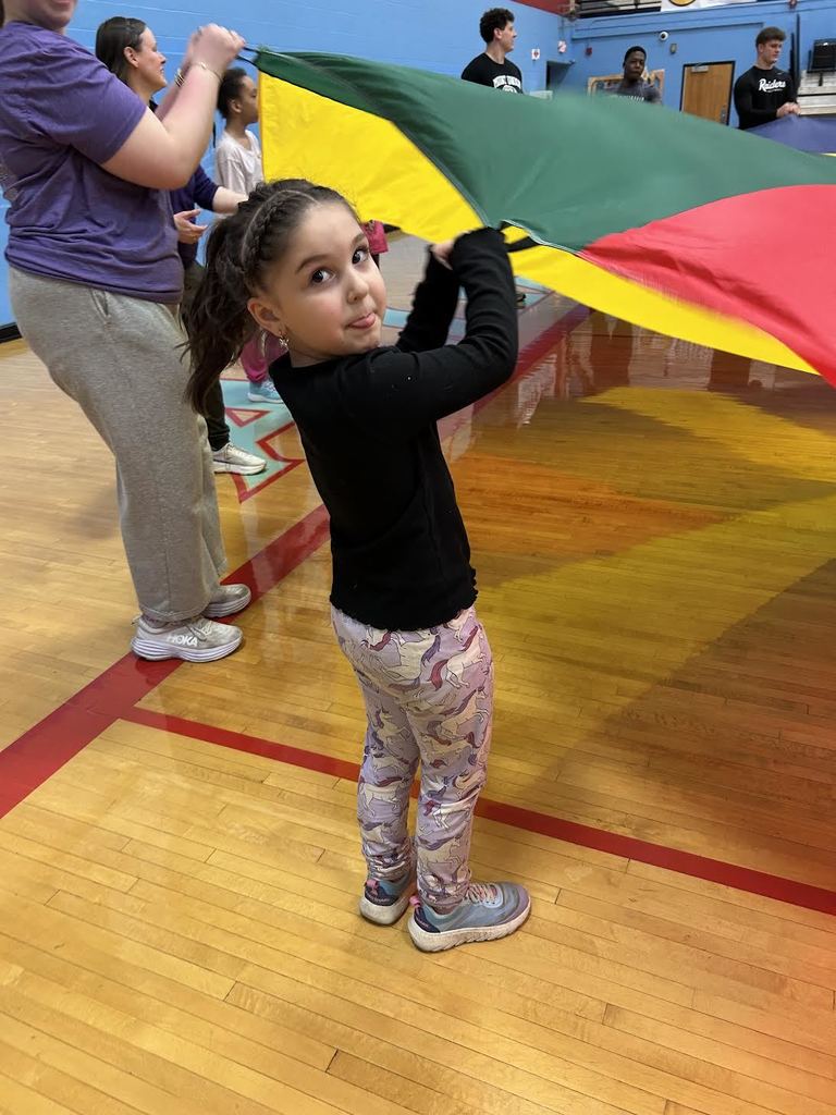 student smiling while holding the parachute.