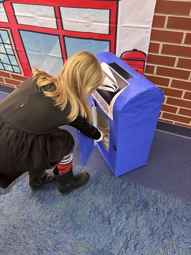 Student grabbling mail out of a fake mail box
