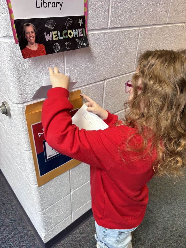 Student putting mail in a fake mail box