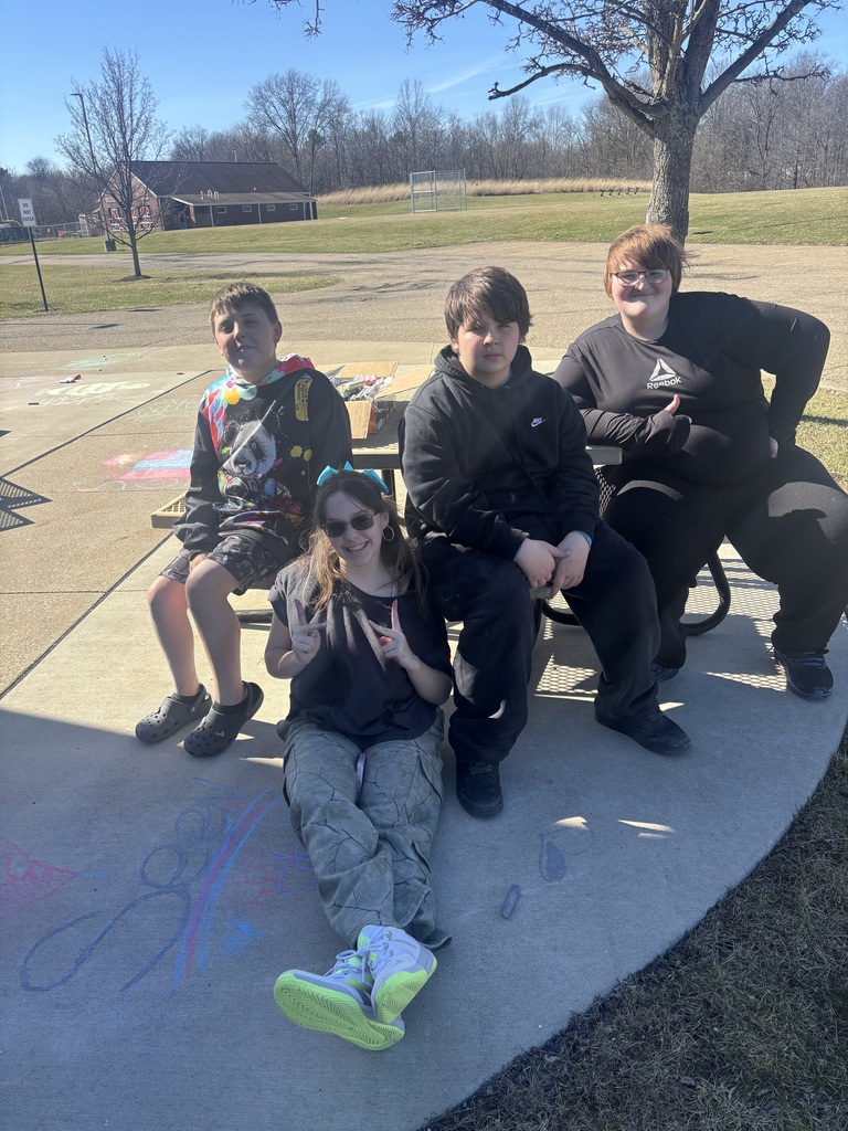 4 students from the club posting for a group picture by the chalk drawing