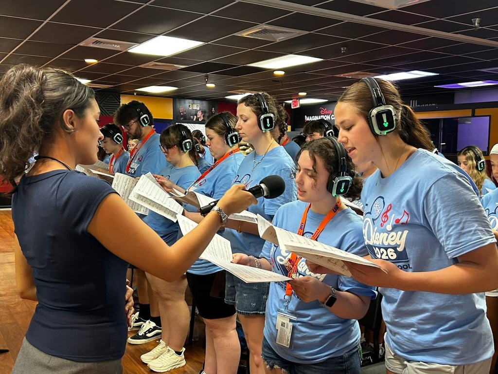 A group of students wearing headphones and singing