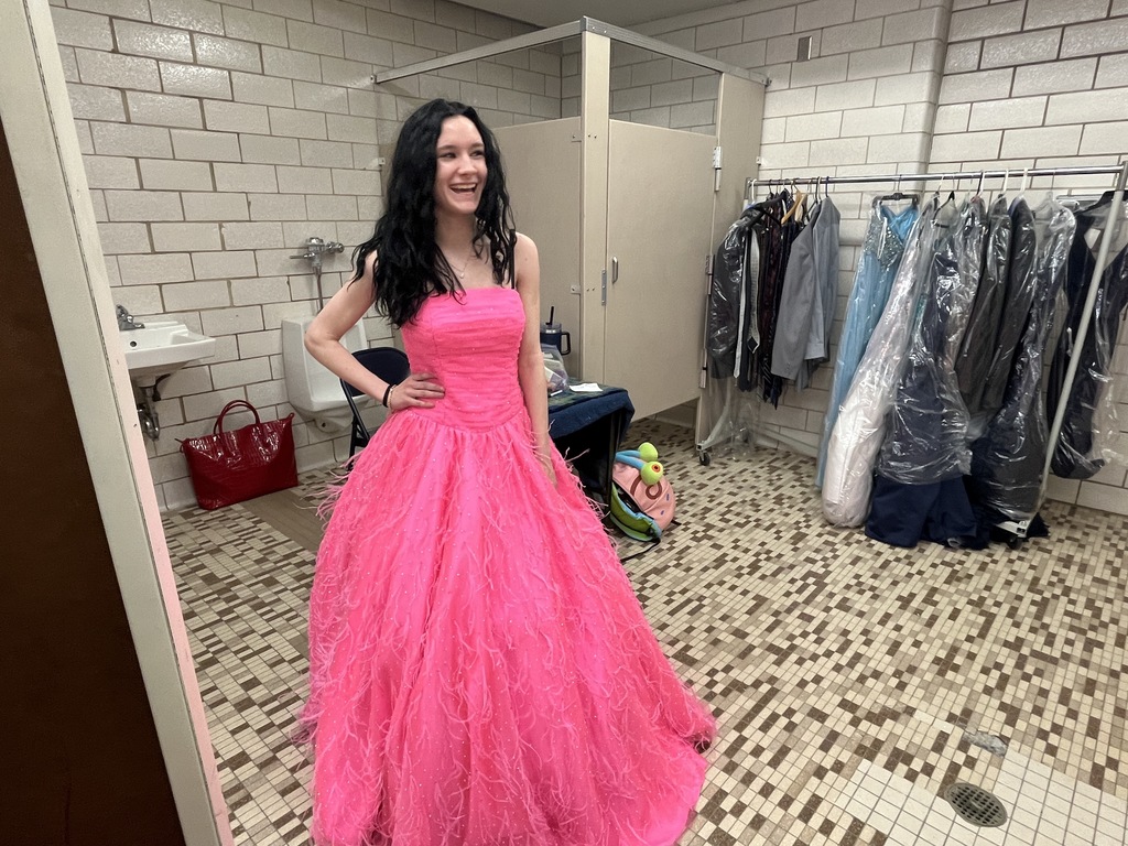 a student smiles while wearing a hot pink dress