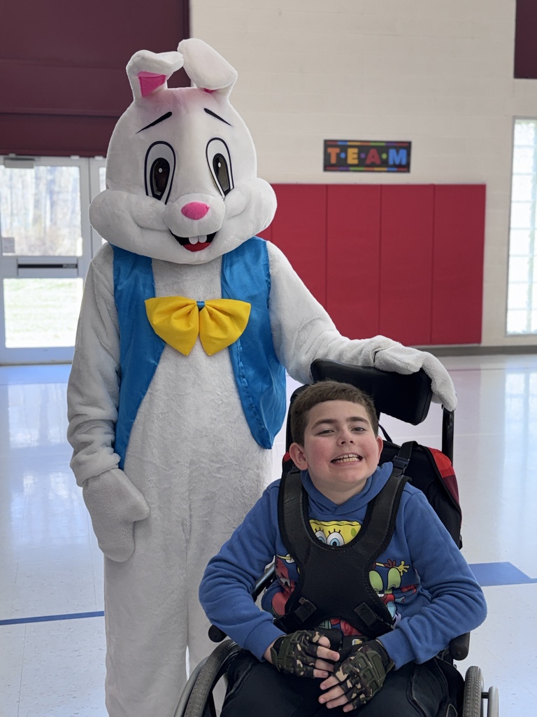 students smiling while next to the easter bunny