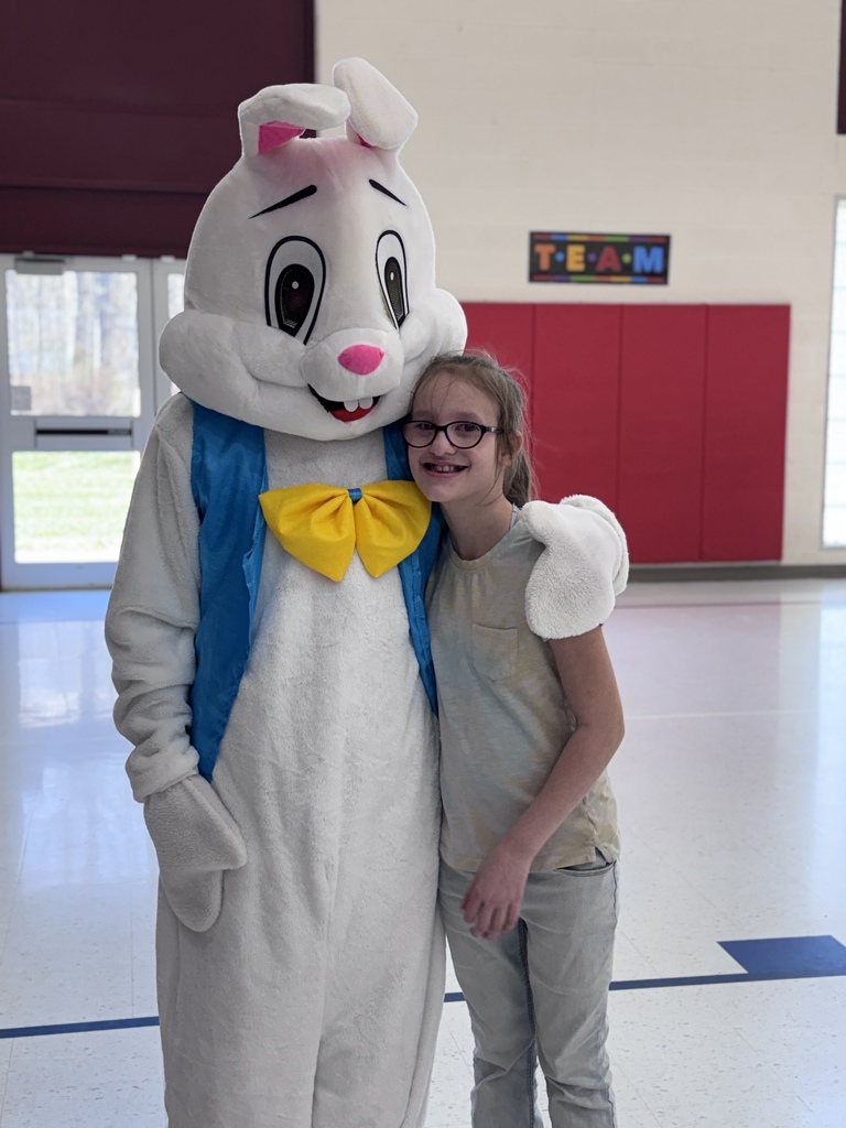 students smiling while next to the easter bunny