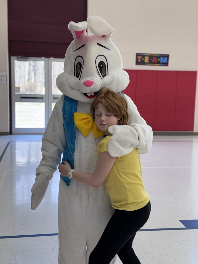 students smiling while next to the easter bunny