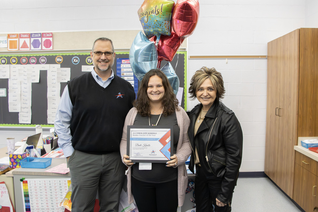 Baeli Kimble smiles while holding her certificate declaring her as the Rookie Teacher of the year with Principal Lori Gasparil on her right and Superintendent Rob Gress on her left