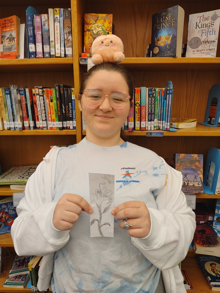 Student holding up the bookmark they designed