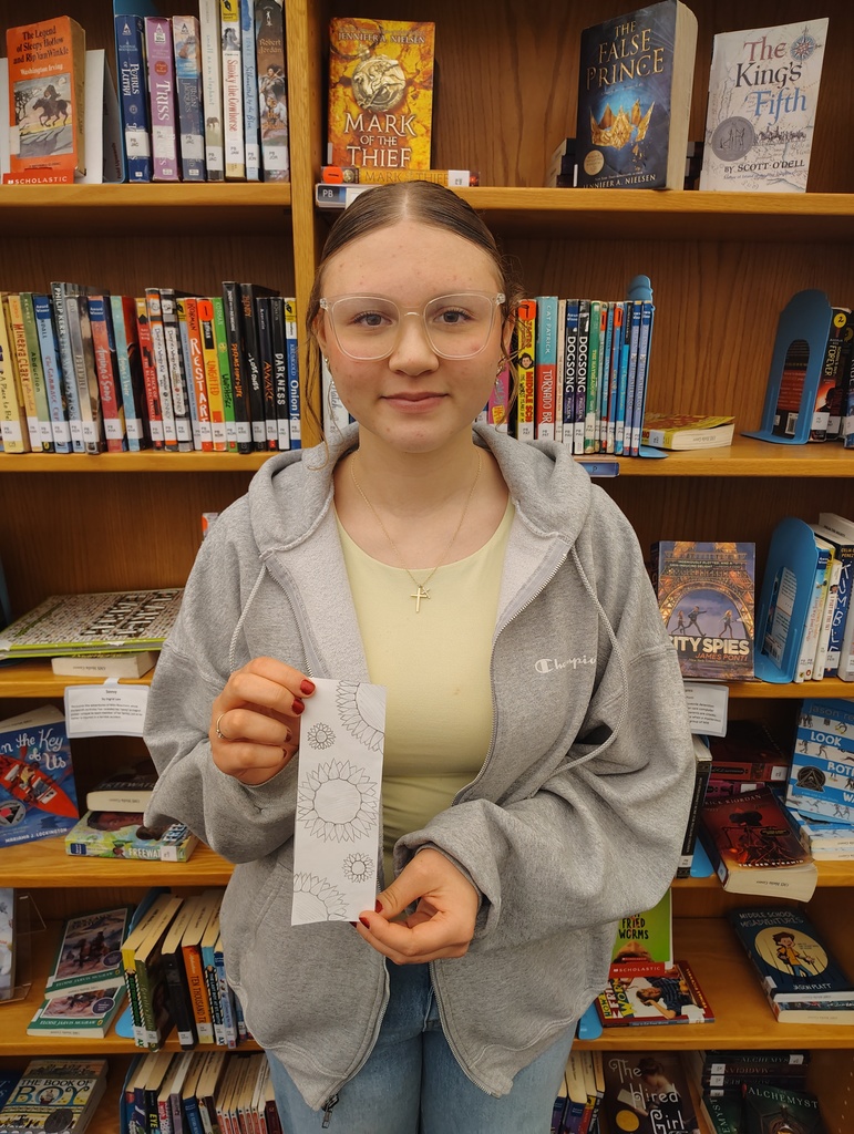 Student holding up the bookmark they designed