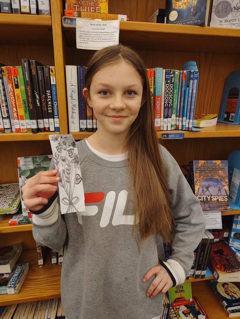 Student holding up the bookmark they designed