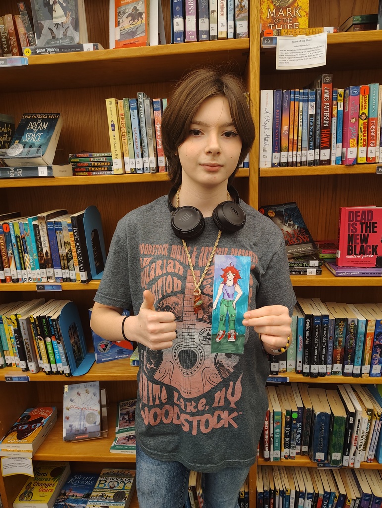 Student holding up the bookmark they designed