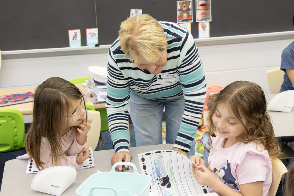Student reading their book an an adult