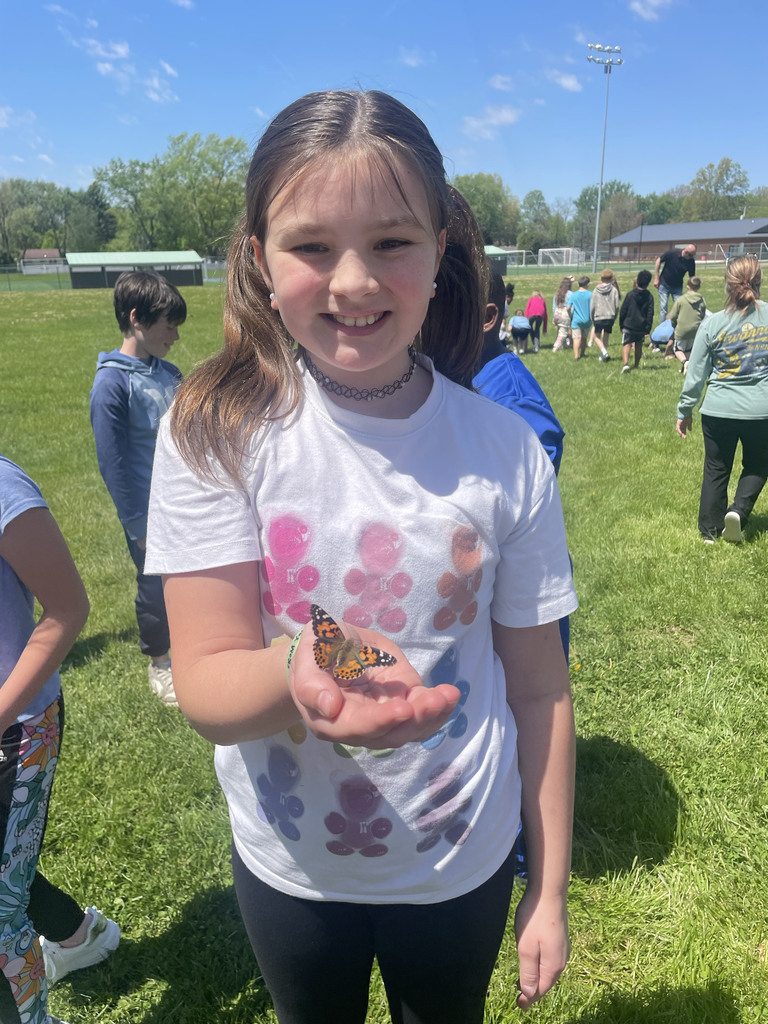 Students smiling with butterflies on their fingers