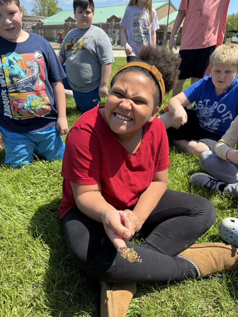 Students smiling with butterflies on their fingers