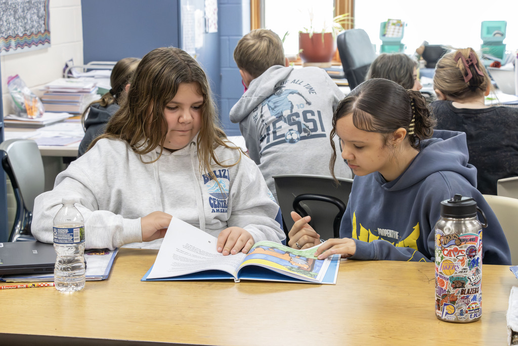 two students reading through the book