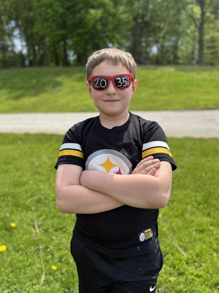 Students smiling while wearing red sun glasses that say "2035" on them.