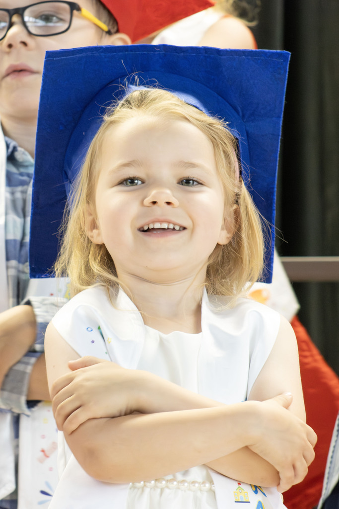 student smiling while wearing a blue graduation cap