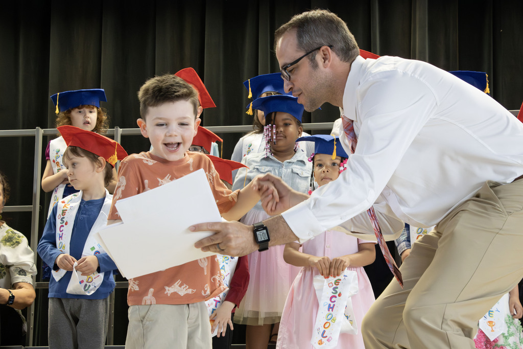 student smiling while getting his certificates