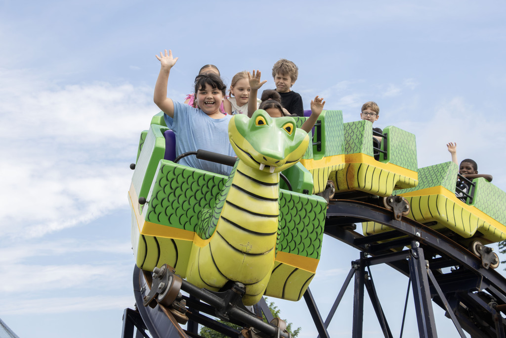 students smiling while riding a roller coaster