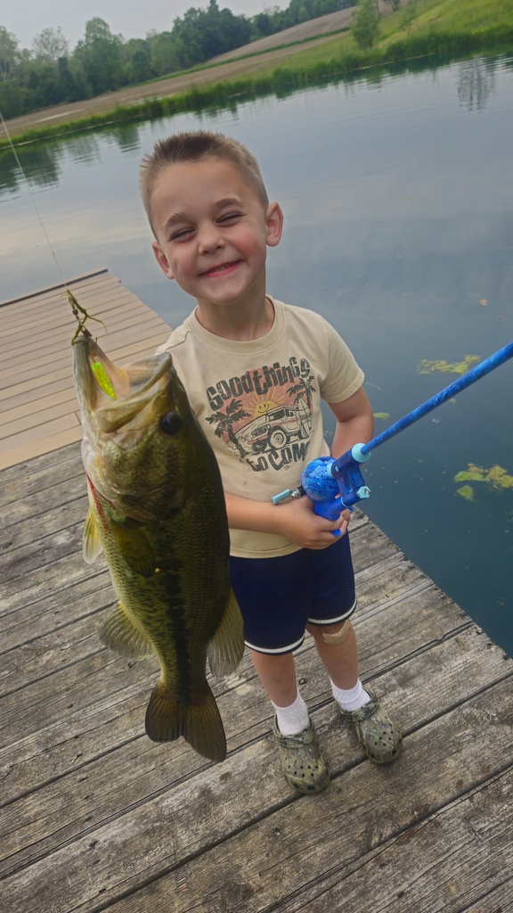 nash smiling while holding a pool with a big bass on it