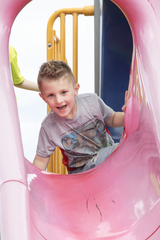 a student smiles while at the top of the slide