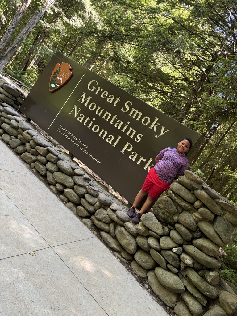 Russell standing in front of the sign that says Great Smoky Mountains National Park